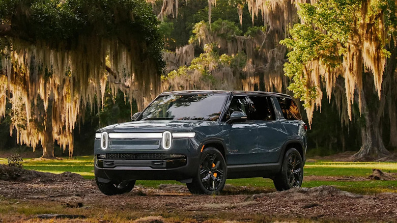 2025 Rivian R1S in the woods front 3/4 view