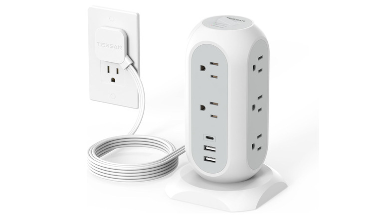 A plugged-in surge protector power strip over a white background