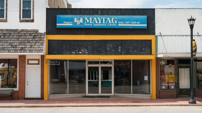 A storefront view of a Maytag Home Appliance Center featuring its blue sign with the repairman logo.