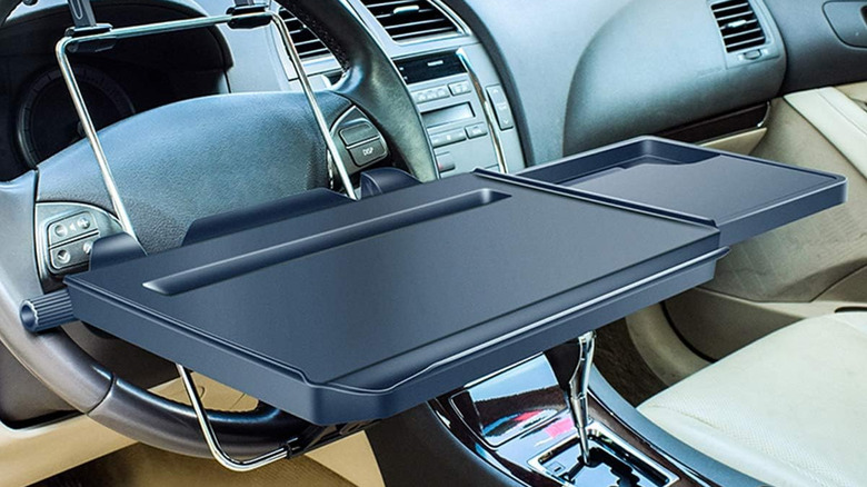 A car steering wheel with a tray mounted in front of it