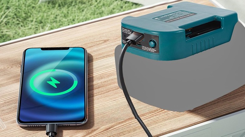 The dual-port adapter connected to a battery while plugged into a smartphone