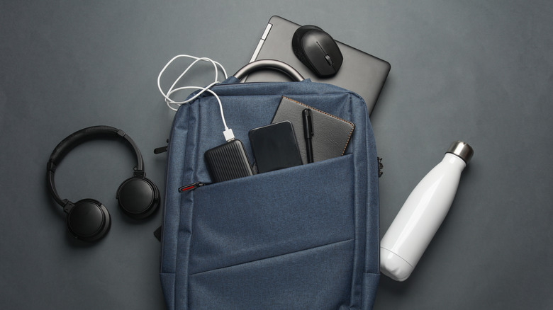 Backpack full of various electronic gadgets resting on a table