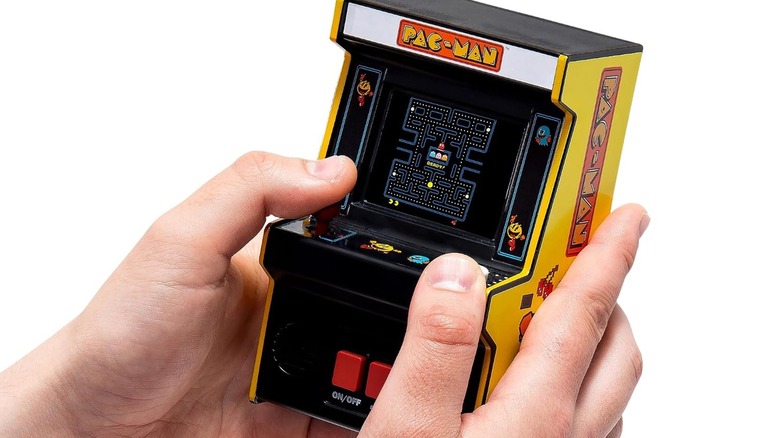 A person holding an Arcade Classics Pac-Man