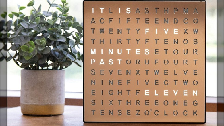 The Sharper Image LED Word Digital Clock beside a potted plant