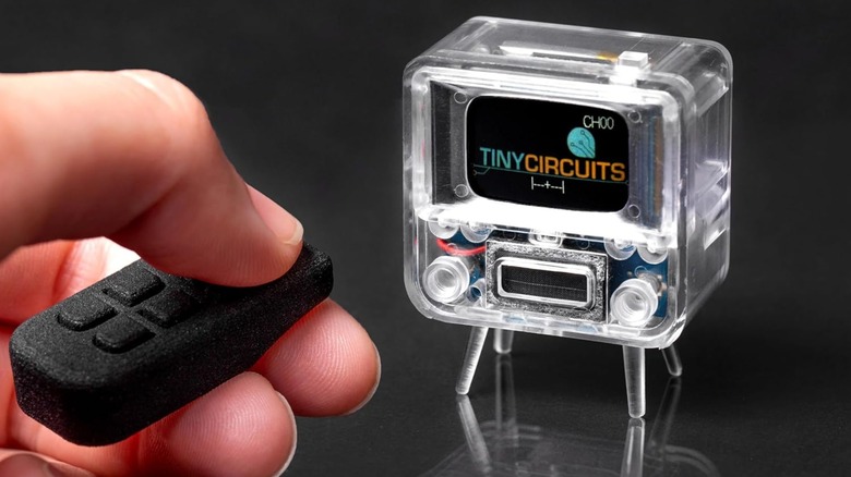 A person using the remote control with a TinyCircuits TinyTV 2