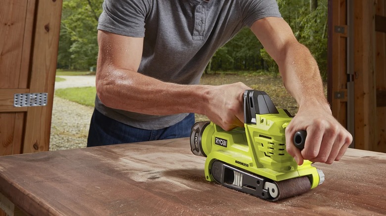 sanding a table top with belt sander
