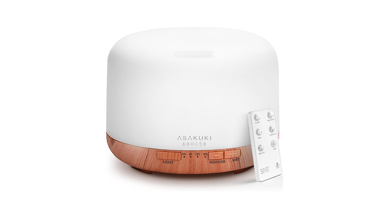 An Asakuki essential oil diffuser and remote against a white background.