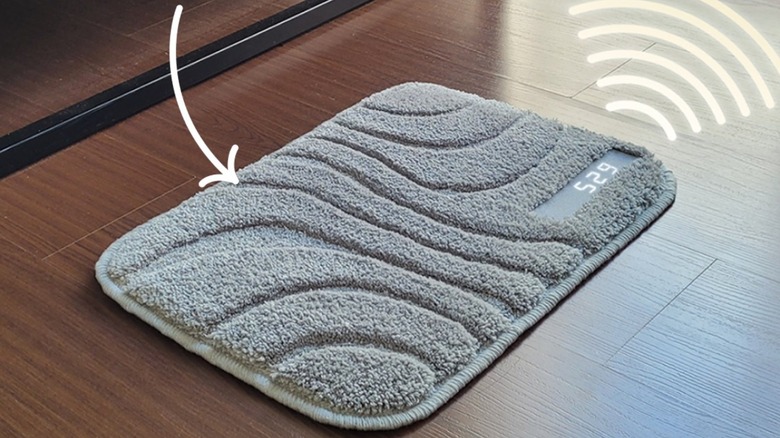 A Ruggie alarm clock mat on a wooden floor with an arrow pointing on it