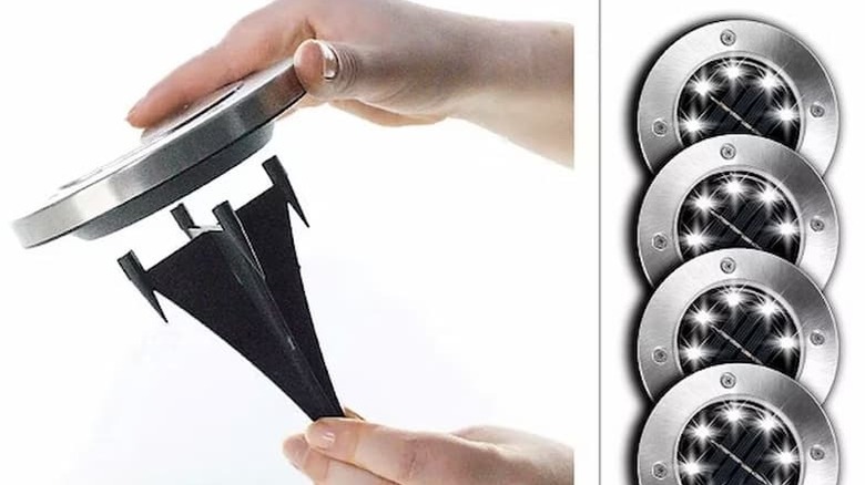 Someone putting solar power disk lights on a pin.