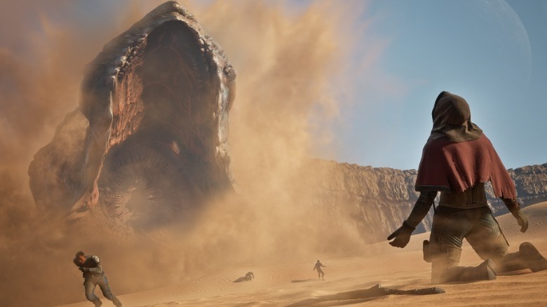 Screenshot from "Dune: Awakening" showing a person kneeling in front of a sandworm