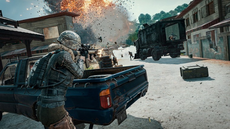 Screenshot from "PUBG: Battlegrounds" showing a player firing while using a pickup truck as cover