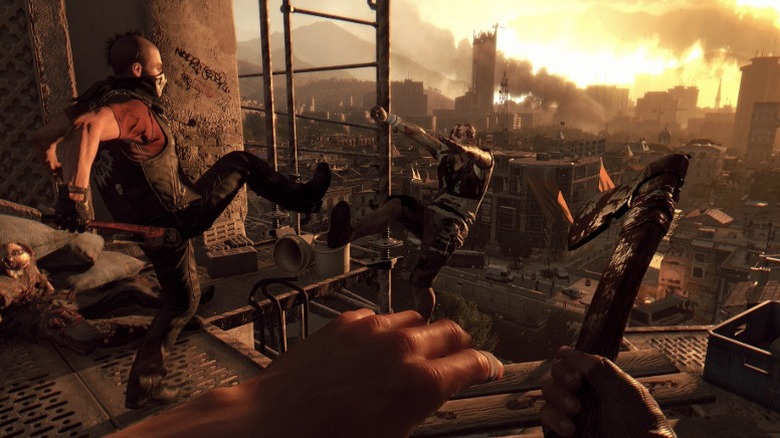 Screenshot from "Dying Light" showing a person kicking a zombie off scaffolding