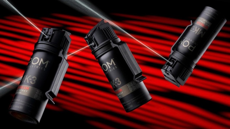 three cans of pepper spray on an abstract background.