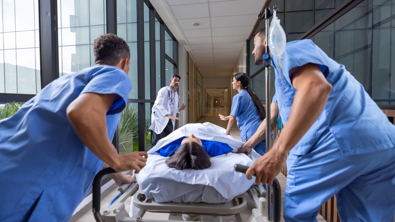 Medical staff rushing a person on a gurney in a hospital