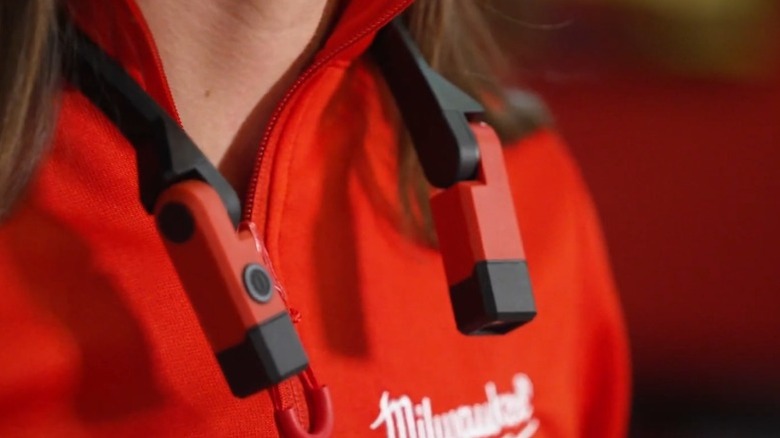 Close-up of Milwaukee 400-lumen Neck Light hanging from a long-haired person's neck