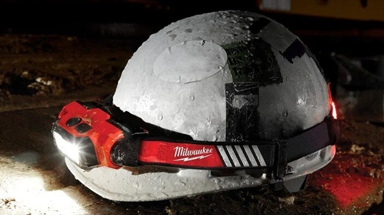 White hard hat on the ground with a Redlithium USB Beacon Hard Hat Light attached