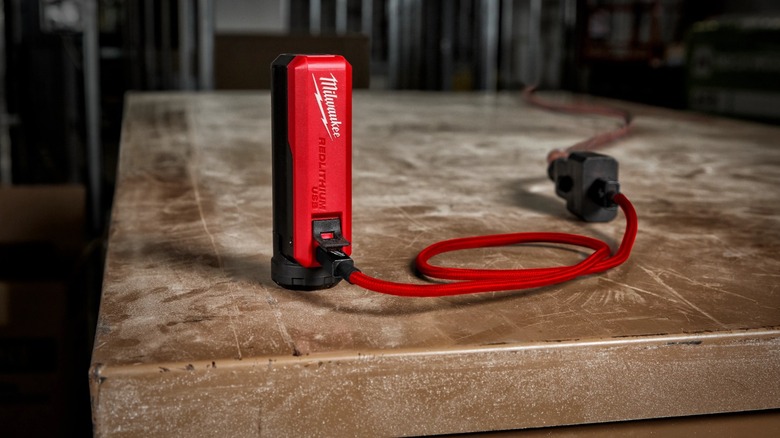Milwaukee USB Charger and Portable Power Source charging on a table