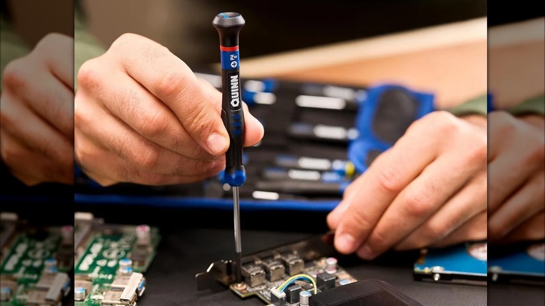 fixing a computer part with Quinn precision screwdriver