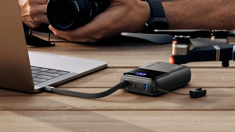 The INIU laptop power bank connected to a laptop on a table outside