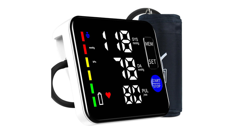 A blood pressure monitor with its cuff over a white background