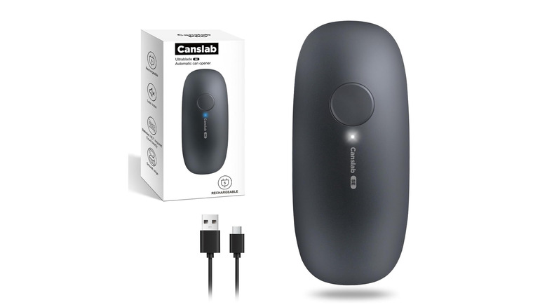 Electric can opener with its box and cable over a white background