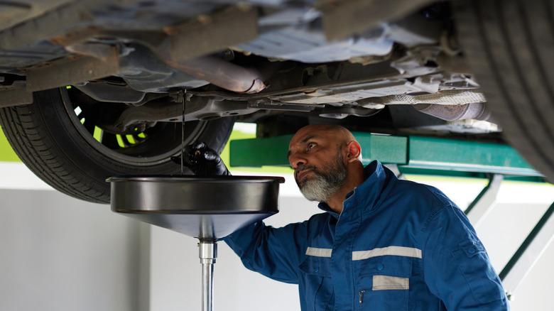 A mechanic changing a customer's oil
