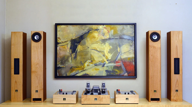 A home audio setup with a painting on the wall