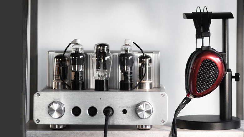 A photo with a set of headphones and a tube amp