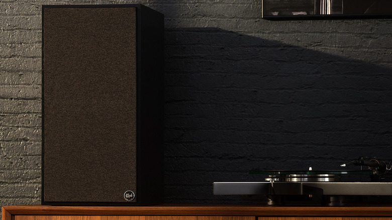 A Klipsch speaker on a table with a turntable