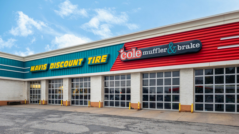 The garage storefront of a Cole Muffler and Brake store next to a storefront of its parent company, Mavis Discount TIre.