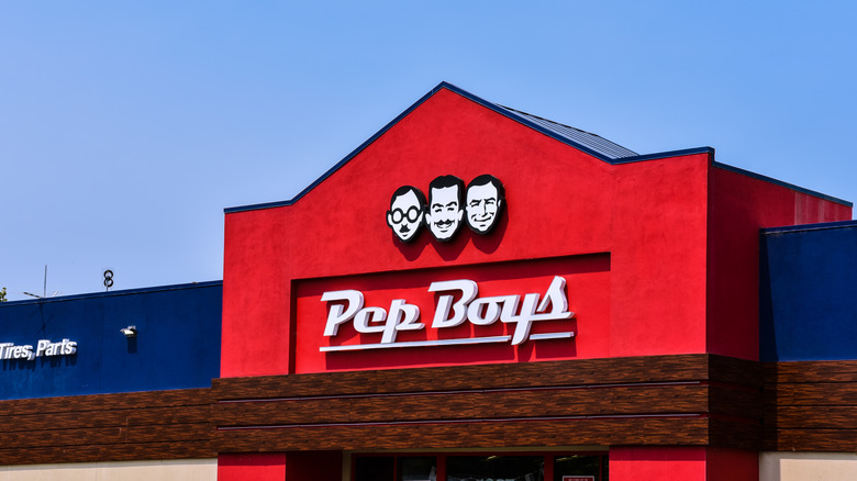 A massive red garage for the Pep Boys auto service chain against a clear blue summer sky.