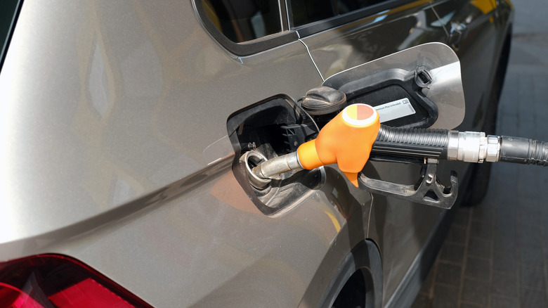 Shell gas pump nozzle in car