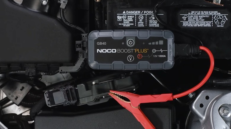 Noco Boost GB40 jump starter on top of a car engine.