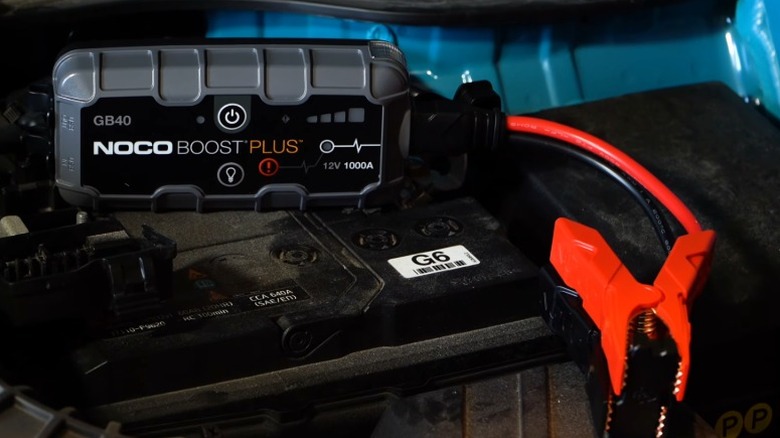 Noco Boost GB40 jump starter placed on top of a car battery.