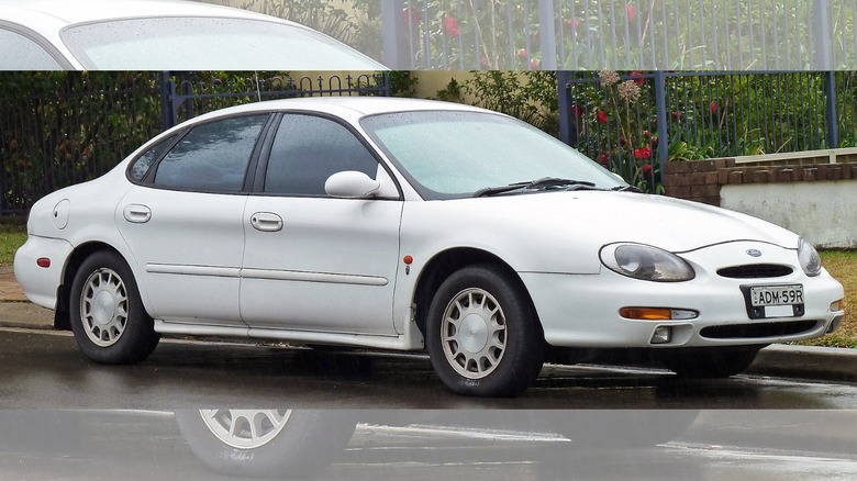 a white 1996 Ford Taurus parked on the side of the road