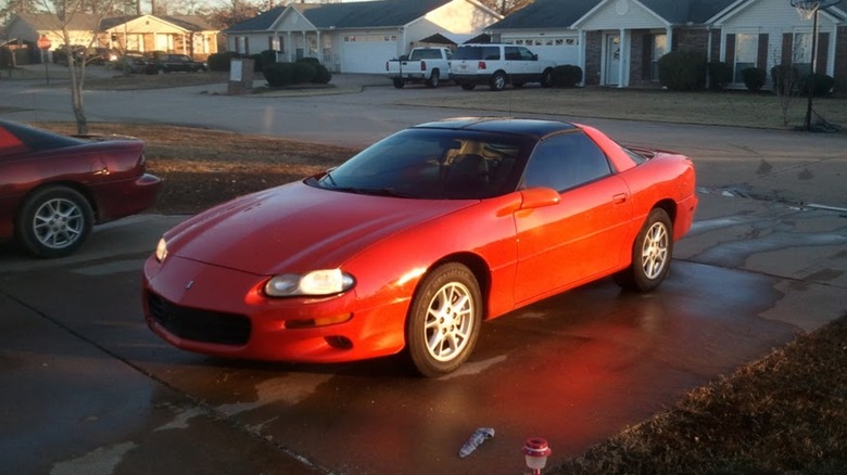 a Hugger Orange 1999 Chevrolet Camaro parked on a driveway