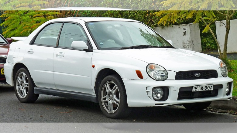 a white 2001 Subaru Impreza parked at the curb