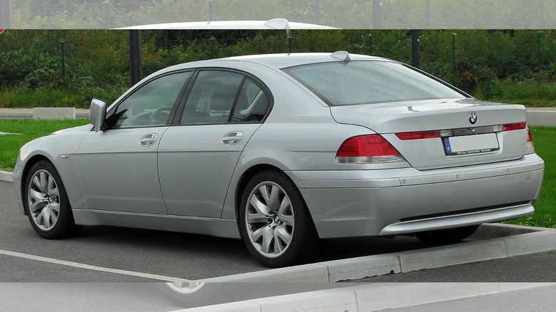 a silver 2002 BMW 7 series in a parking lot with its side mirrors closed