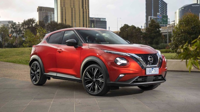 a red 2020 Nissan Juke (F16) parked on the patio with buildings in the background