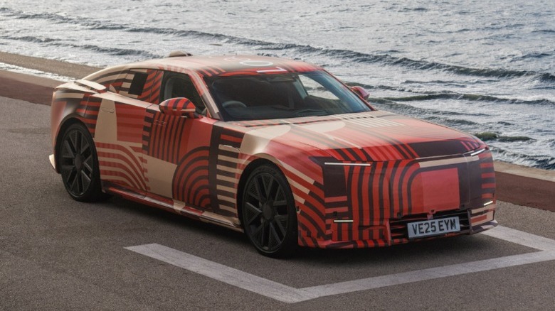 Jaguar Type 01 in a vibrant wrap parked on a seaside road.