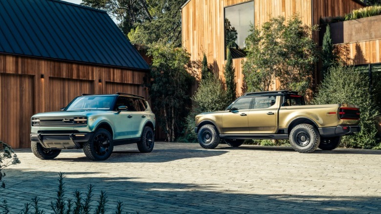 Scout Traveler and Terra parked in front of a modern wood-paneled house.