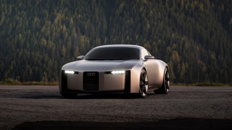 Silver Audi Concept C EV parked on a rural road with forested mountains in the distance