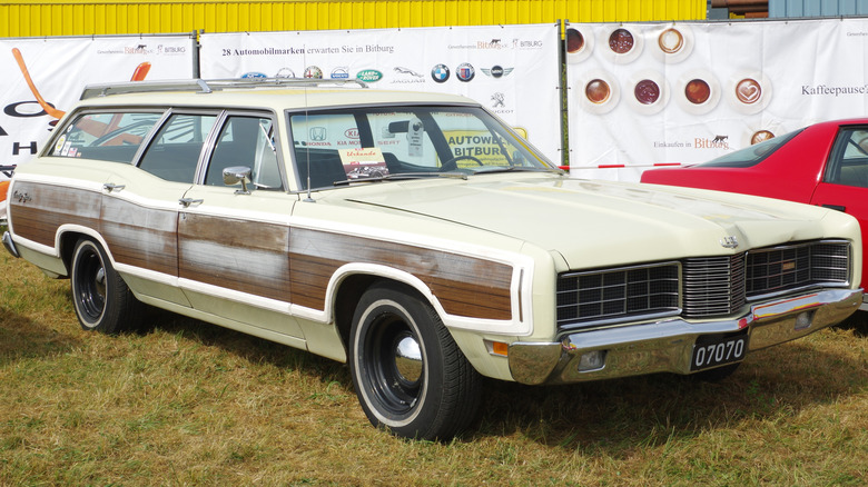 1970 Ford Country Squire station wagon parked on the grass at a car show