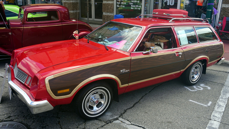 Ford Pinto station wagon on display at a car show, finished in red and the ubiquitous wood paneling.