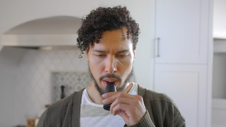 Man blowing into the Lumen Metabolism Tracker