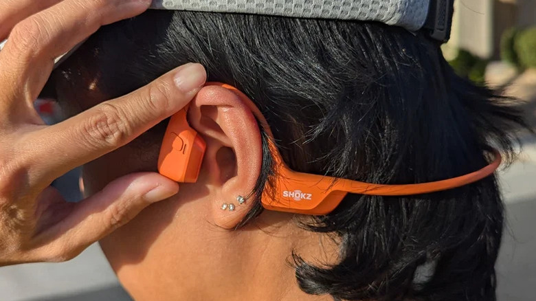 SlashGear's reviewer using the Shokz OpenRun Pro 2 headphones