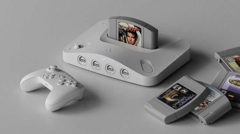 White Analogue 3D console with a white controller and Nintendo 64 cartridges on a gray surface