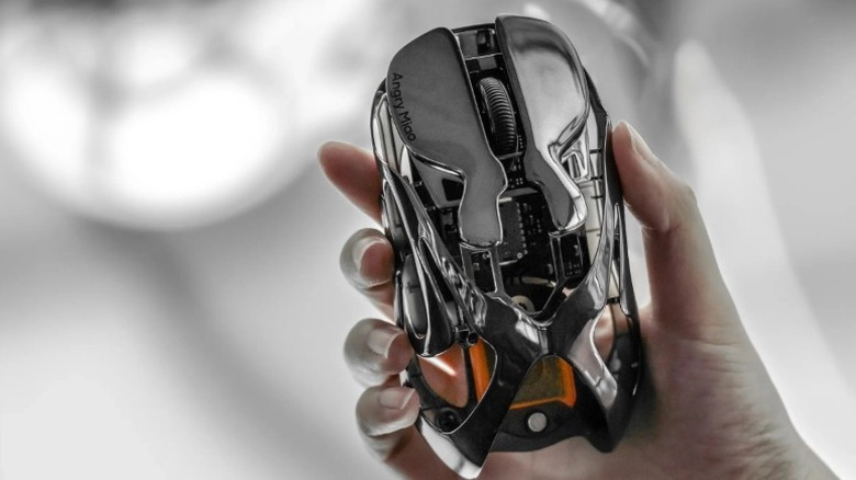 Hand holding up an Angry Miao Infinity mouse in the Mirror Shadow finish