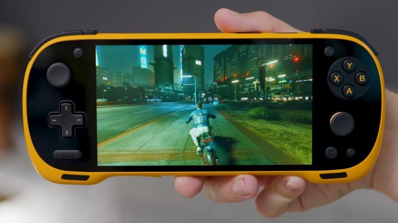 Hand holding up an orange Konkr Pocket Fit gaming handheld with "Cyberpunk 2077" on screen