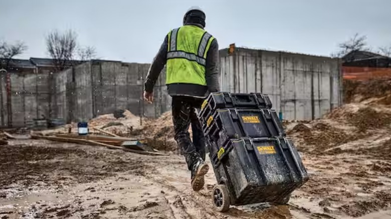 worker dragging ToughSystem boxes across muddy jobsite